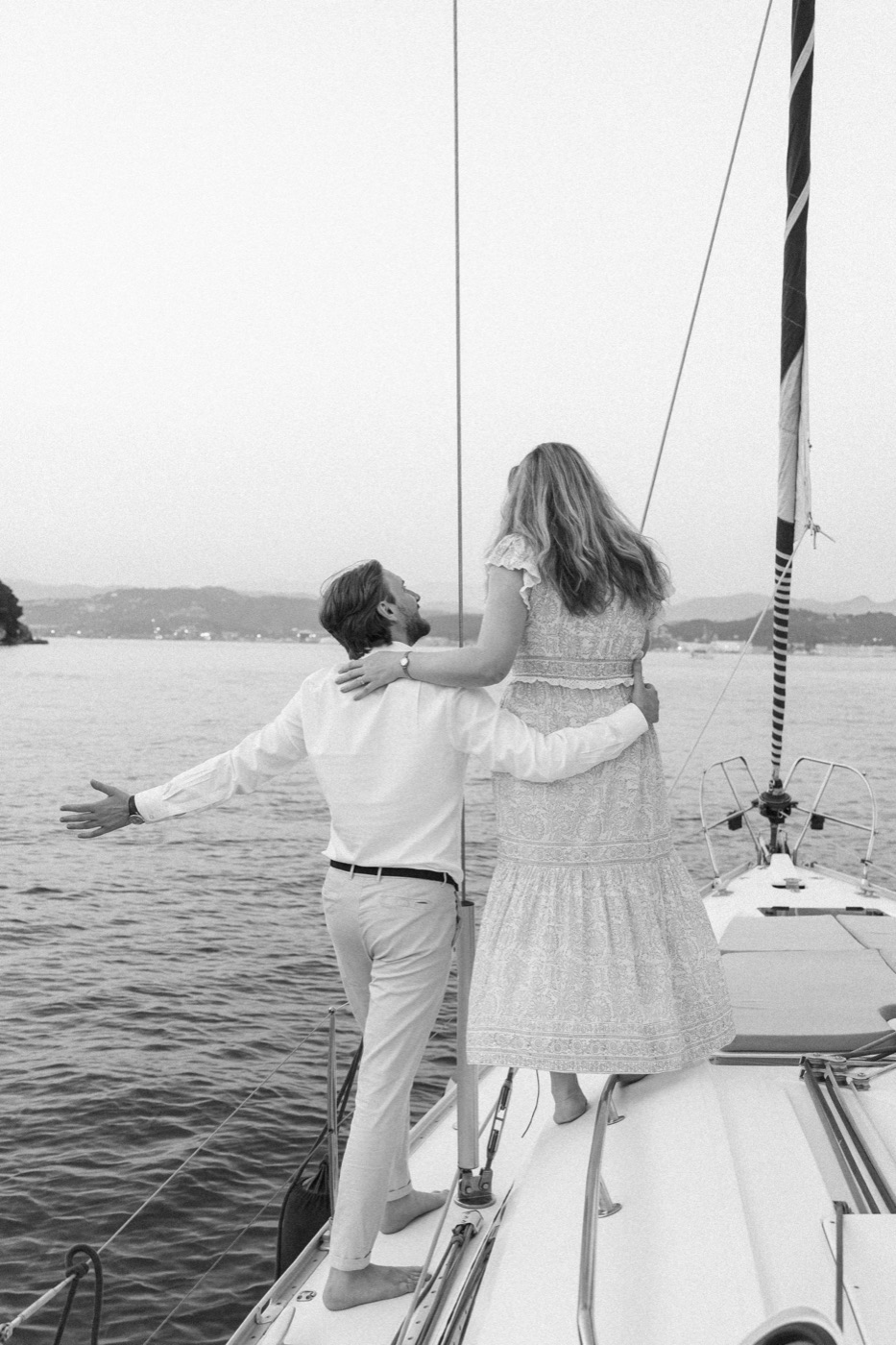 Jess with her arms open wide at the bow, in black and white